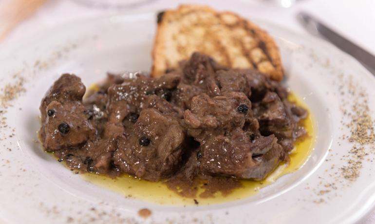 Spezzatino di carne con pepe nero e pane grigliato.