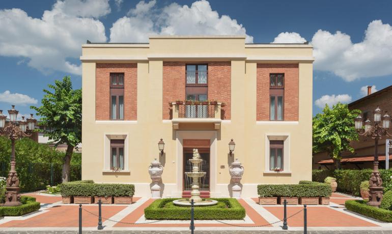 Edificio elegante con fontana, mattoni rossi e lampioni decorativi.