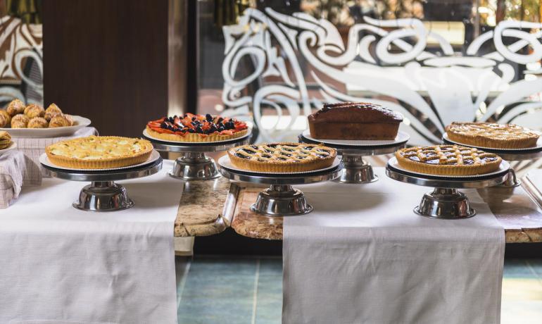Una varietà di torte su alzate in un ambiente elegante.